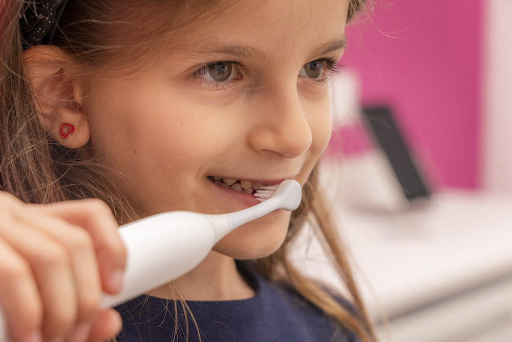 Bambina che cura i suoi denti decidui